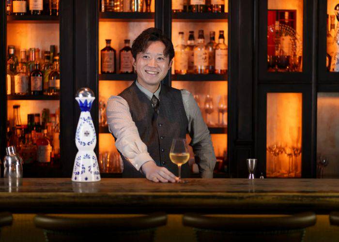 The head bartender of The SG Club, Tokumitsu Ryota, smiling from behind the bar.